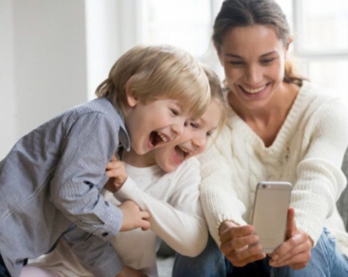 young mom taking selfie with kids