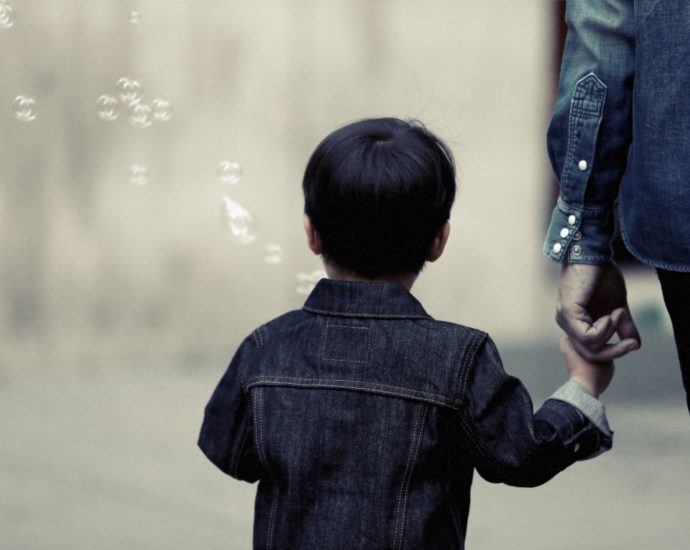 parent holding hand of a little boy