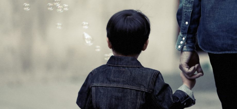 parent holding hand of a little boy