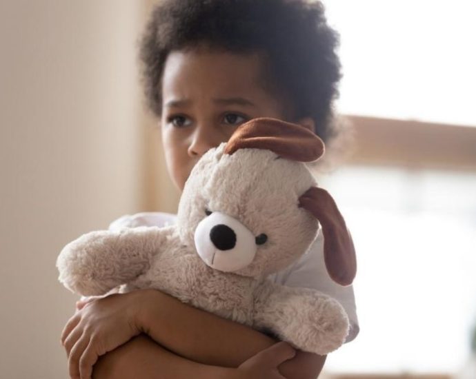 sad little boy hugging teddy bear