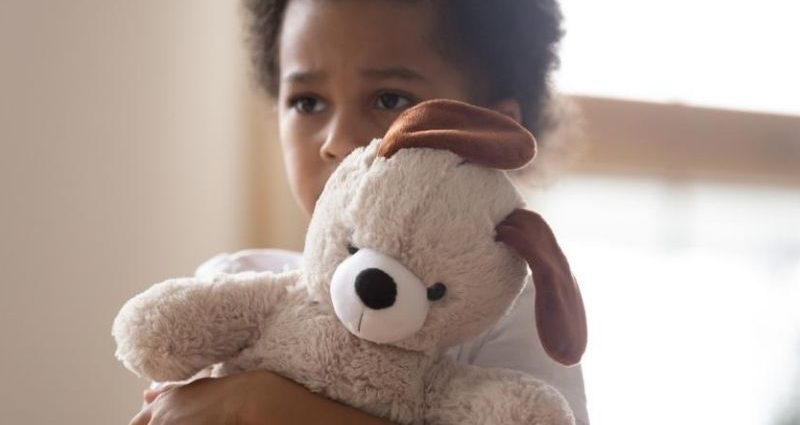 sad little boy hugging teddy bear