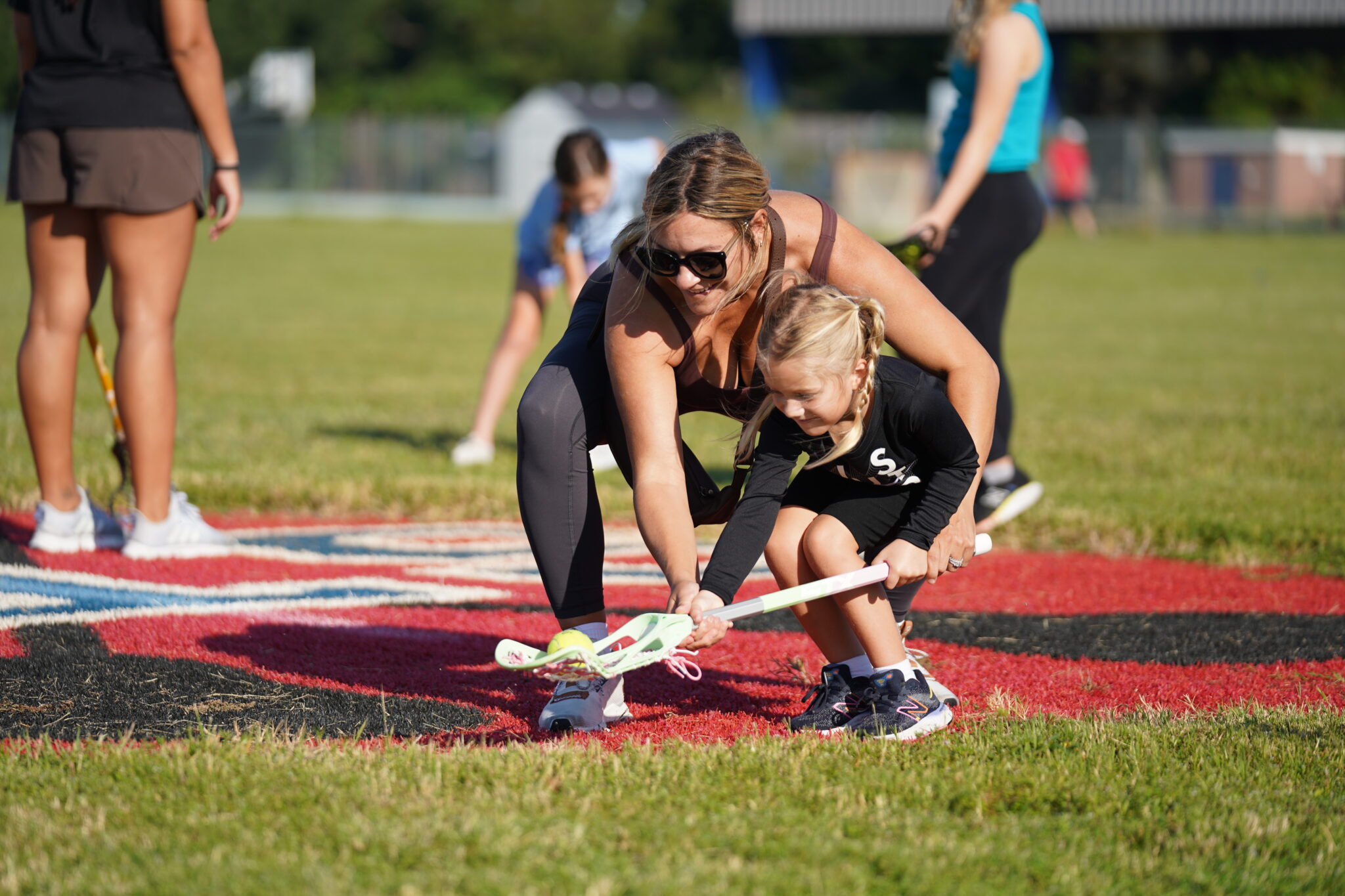 A parent helps a young player at a Signature event. The Signature Foundation runs free Try Sports Days.